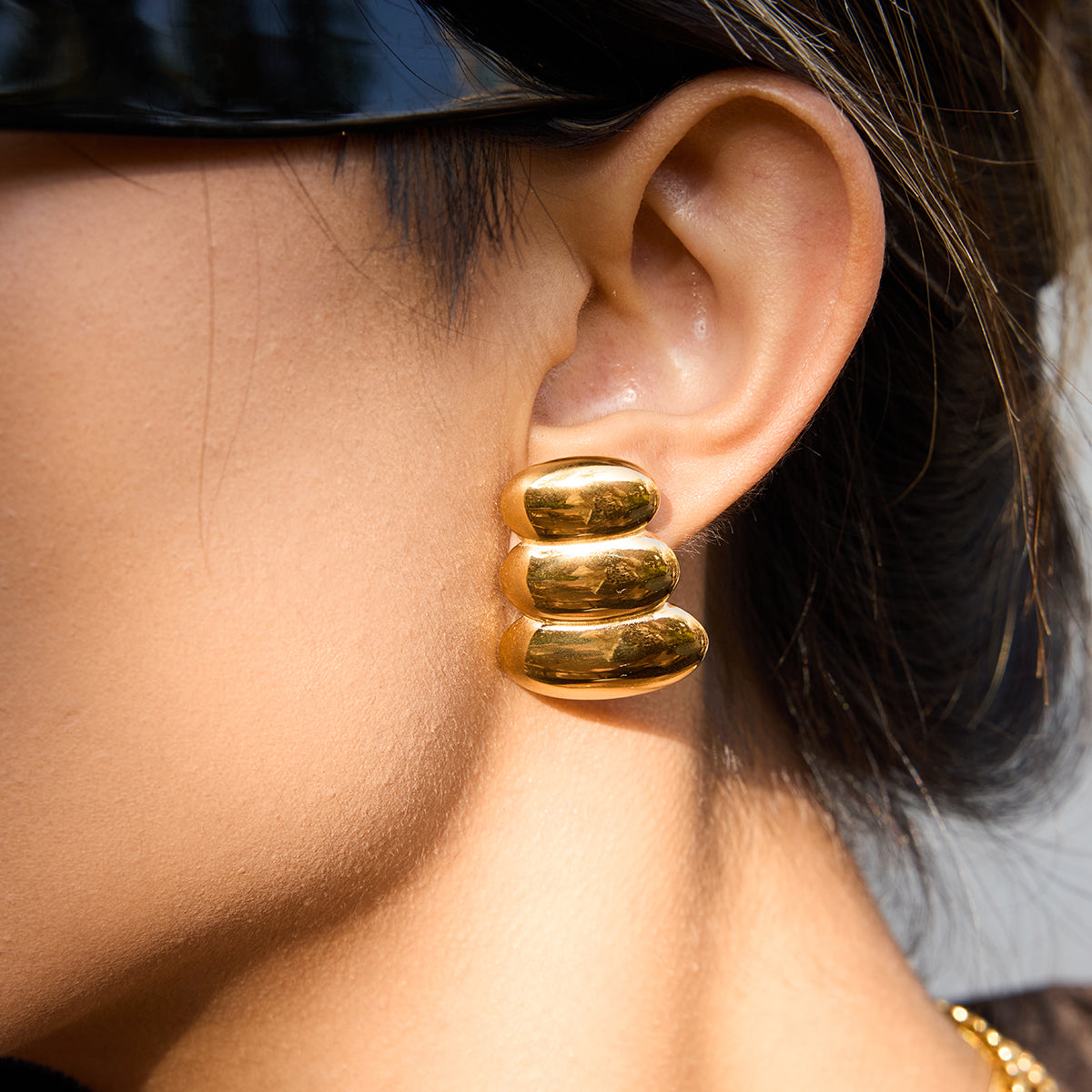 Close-up of a person wearing a gold hoop  Earrings For Women.