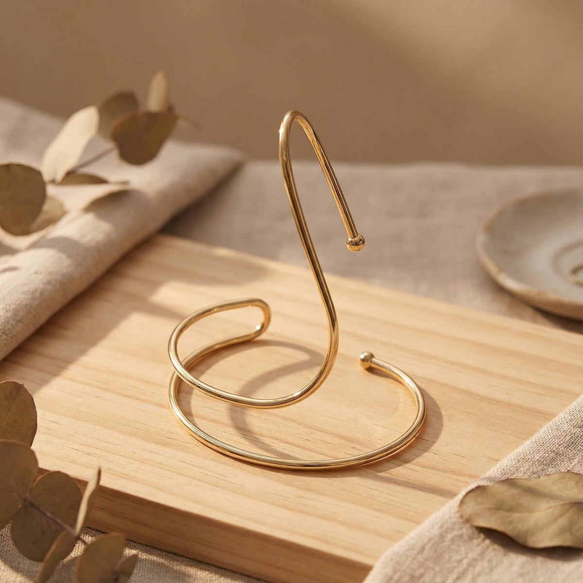 Gold metal stand on a wooden surface with a neutral background