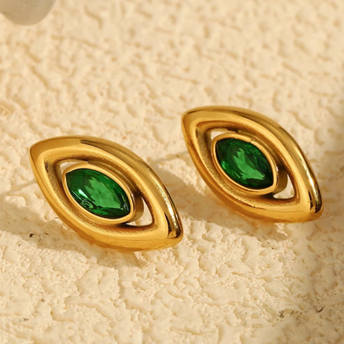 Gold earrings with green gemstones earrings for women on a beige textured background