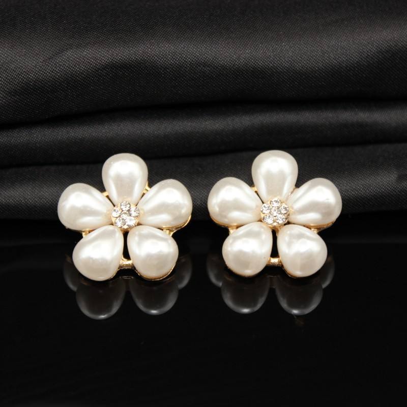 Pair of pearl flower button on a black fabric background